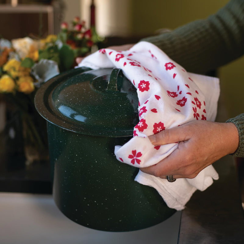 This photo shows a Kei & Molly Sakura flour sack dish towels being used a pot holder.