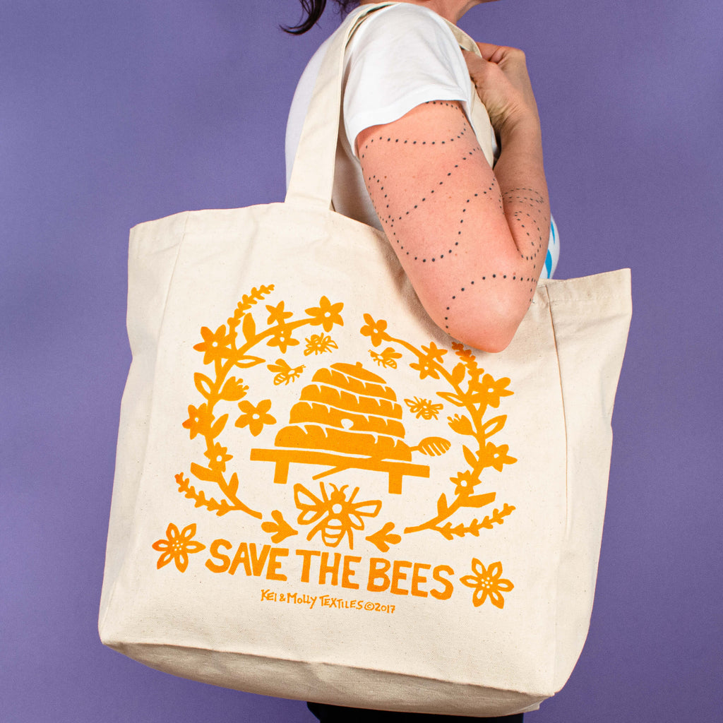 Kei & Molly Tote Bag with Bees Design in Squash Held by Model