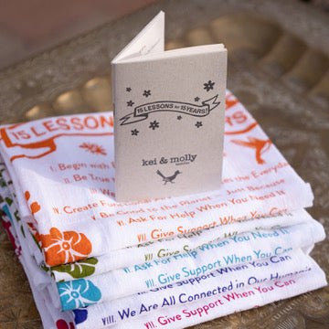 Stack of Kei & Molly Textles towels with 15 Lessons for 15 Years Booklet on top.