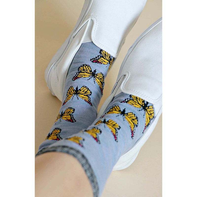 Model wearing Grey Tabbysocks Monarch Butterfly Socks - Unisex