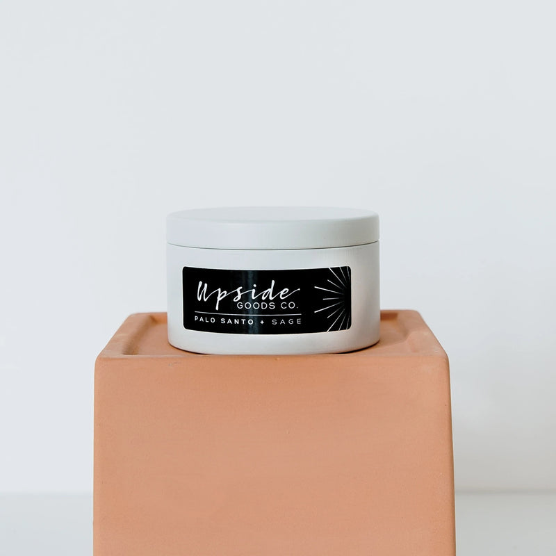 Palo Santo + Sage Candle by Upside Goods Co.  in a white tin; front view with lid on