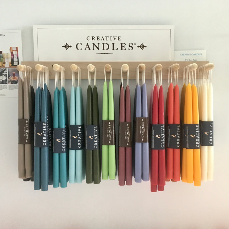 Creative taper candles hanging from hooks in all colors