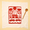 Kei & Molly Flour Sack Dish Towel: Adobe house with trucks, dogs and laundry line printed in color Red propped with a wooden spoon
