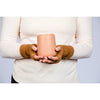 B. B Sheep cashmere fingerless gloves in beige. Model holding a cup.