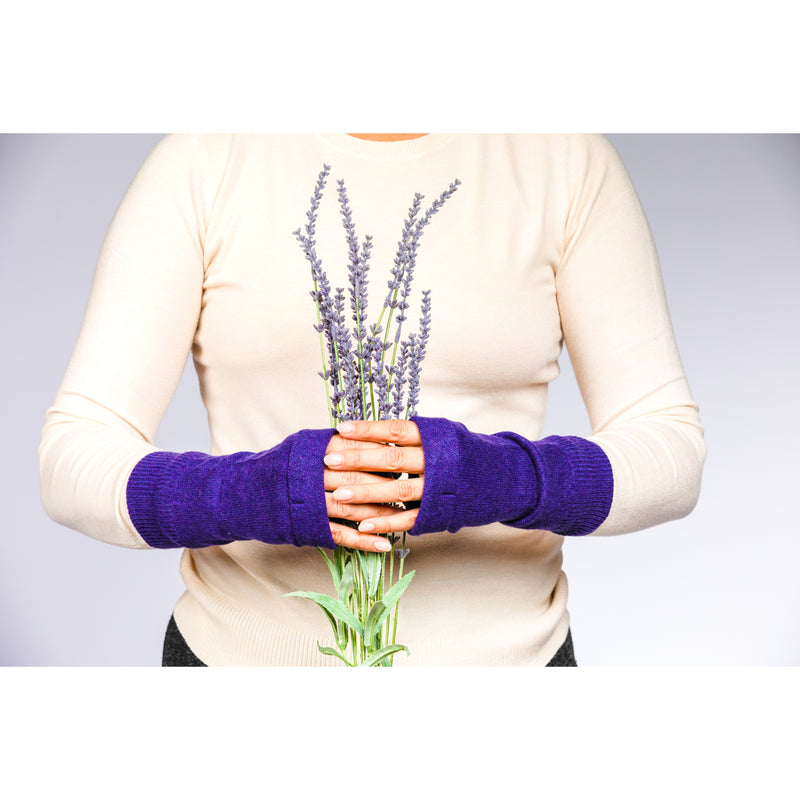 B. B Sheep cashmere fingerless gloves in dark purple. Model holding a lavender bouquet.